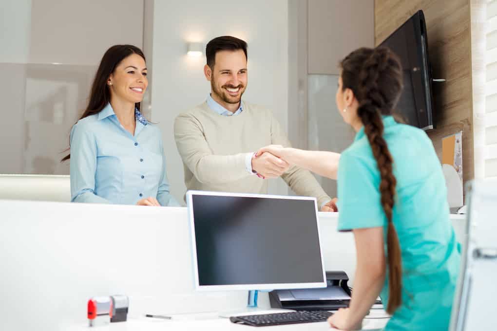 patient shaking hands with dental assistant in office; best way to whiten teeth