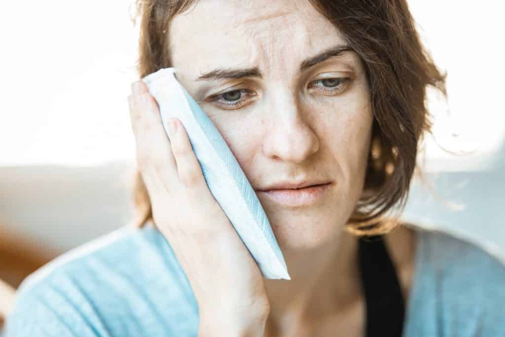 woman with sinus tooth pain; alternatives to dental crowns