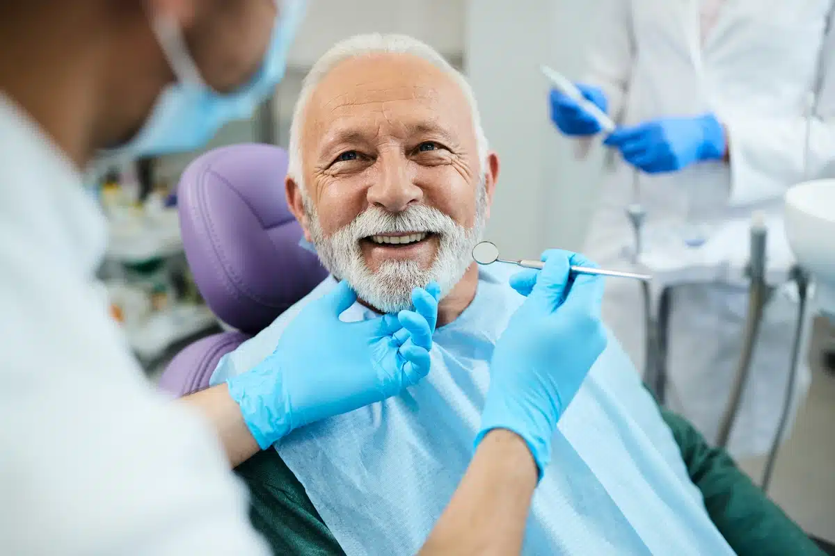 old man sitting in dentist chair learning how to shrink gum pockets