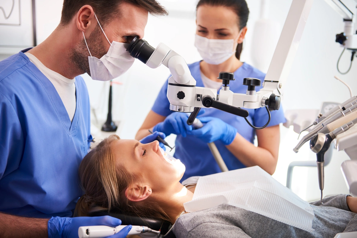 dentist working with dental microscope for patient' treatment