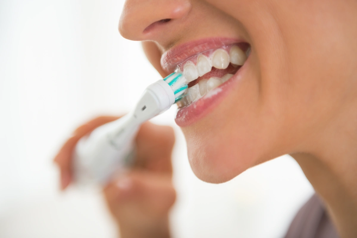 close up to woman brushing her teeth