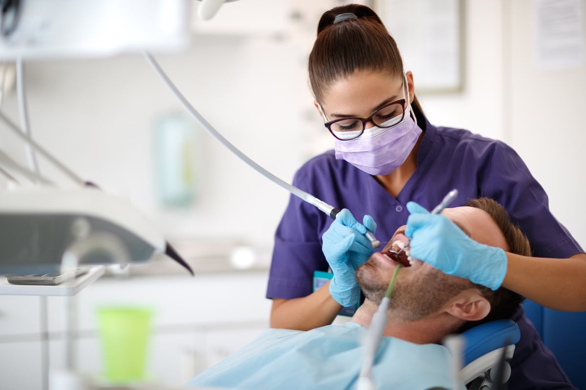 A dentist drilling tooth to patient in dental clinic