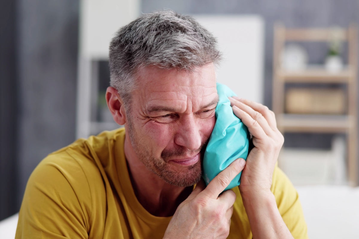 A man holding a blue bag, on his way to seek urgent dental care.